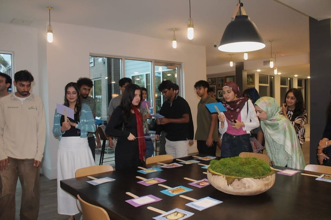 Members holding their reveal cards at the mentor-mentee social